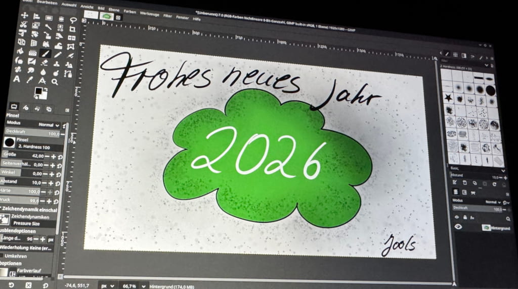 Ein Grafiktablett mit Display, auf dem Gimp geöffnet ist. Auf dem Display sieht man einen Neujahrsgruß mit den Worten Frohes neues Jahr. In einer Art grünen Wolke steht die Zahl 2026.
